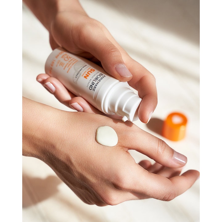 Annemarie Börlind Sun DNA Protect SPF 30 50 ml solbeskyttelse i hvit pumpeflaske med kremet tekstur på en hånd