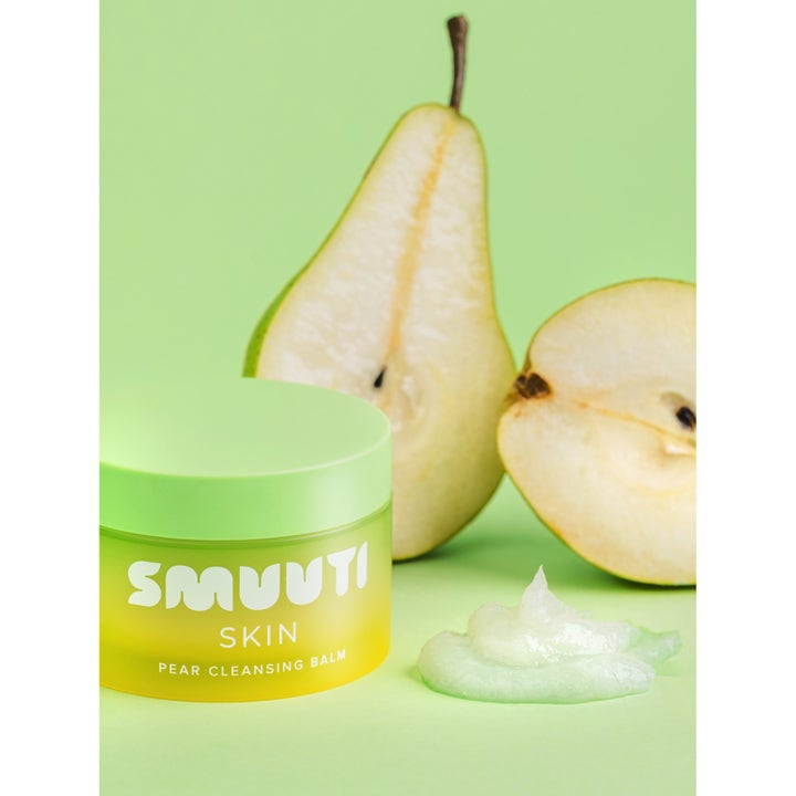 Smuuti Skin Pear Cleansing Balm 100 ml ansiktsrens i grønn krukke ved siden av ferske pærer og myk tekstur.