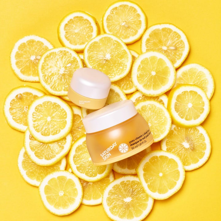 Saturday Skin Yuzu Vitamin C Sleep Mask 50 ml opplysende nattkrem i gul krukke omgitt av friske sitronskiver