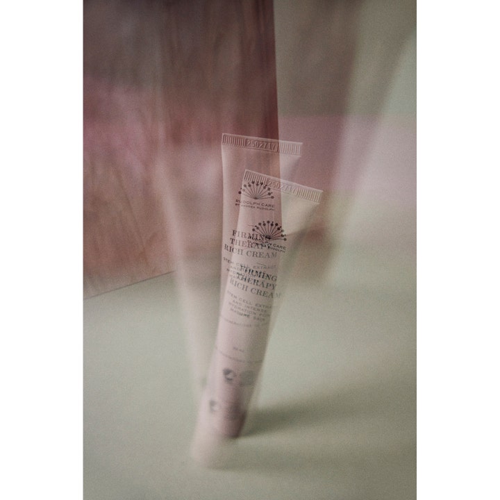 Rudolph Care Firming Therapy Rich Cream 50 ml oppstrammende ansiktskrem vist som to overlappende tuber i en dus setting.