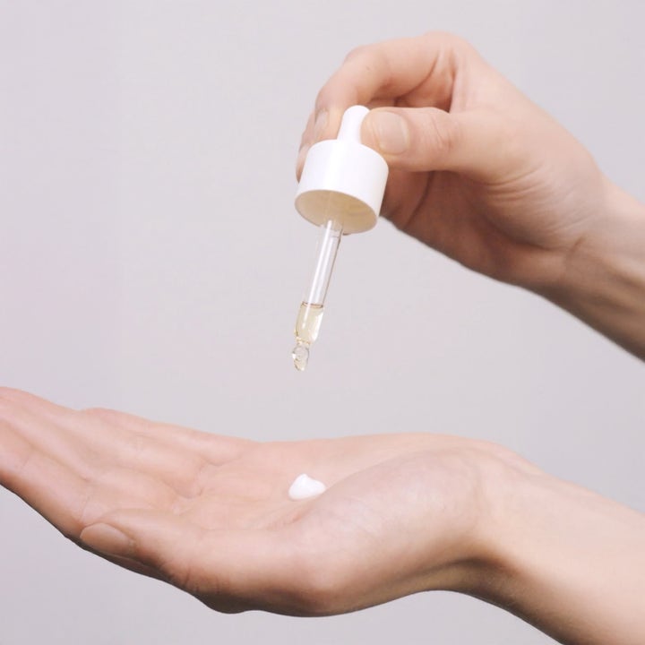 Jorgobé Antioxidant Self-Tan Drops 30 ml selvbruning som dryppes fra en pipette i en hvit krem i håndflaten