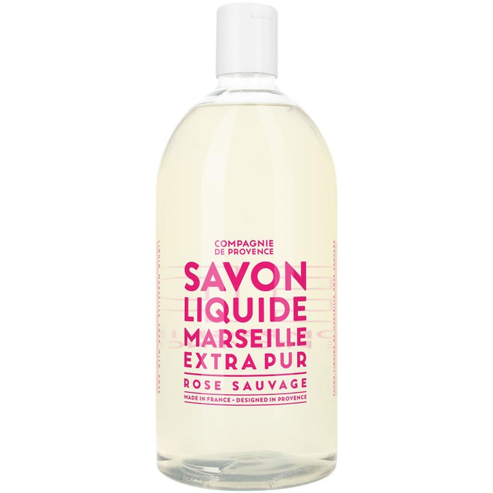 Compagnie de Provence Savon Liquide Rose Sauvage 1000ml flytende såpe i en klar plastflaske med hvit kork og rosa tekst.