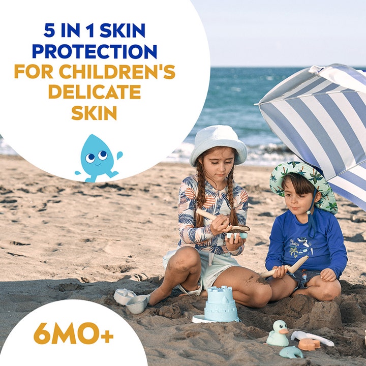 NIVEA Kids Sensitive Protect & Play Sun Spray SPF50+ 270 ml gir 5-i-1 beskyttelse til barn som leker på stranden.