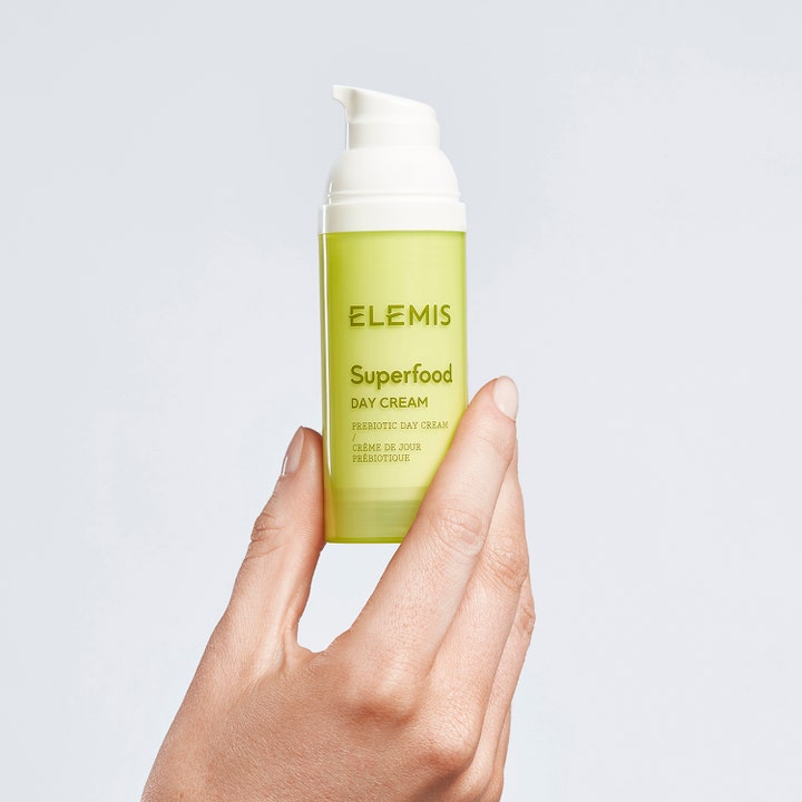 Elemis Superfood Day Cream 50 ml prebiotisk ansiktskrem i en limegrønn pumpeflaske holdt av en hånd