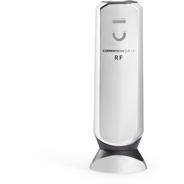 CurrentBody Skin RF Radio Frequency Device for hudstramming i hvit og sølvfarget utførelse som står i en base