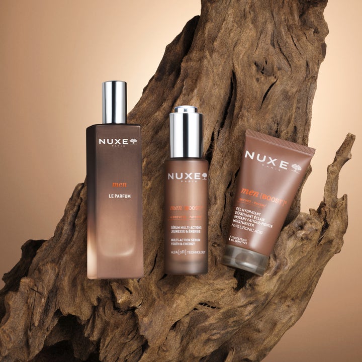 Nuxe Men Multi Action Serum 30 ml energigivende ansiktsserum i brun flaske med sølvpumpe på rustikk trebakgrunn