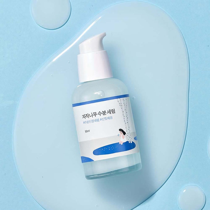 Round Lab Birch Juice Moisturizing Serum 50 ml fuktighetsgivende serum i hvit pumpeflaske omgitt av vanndråper