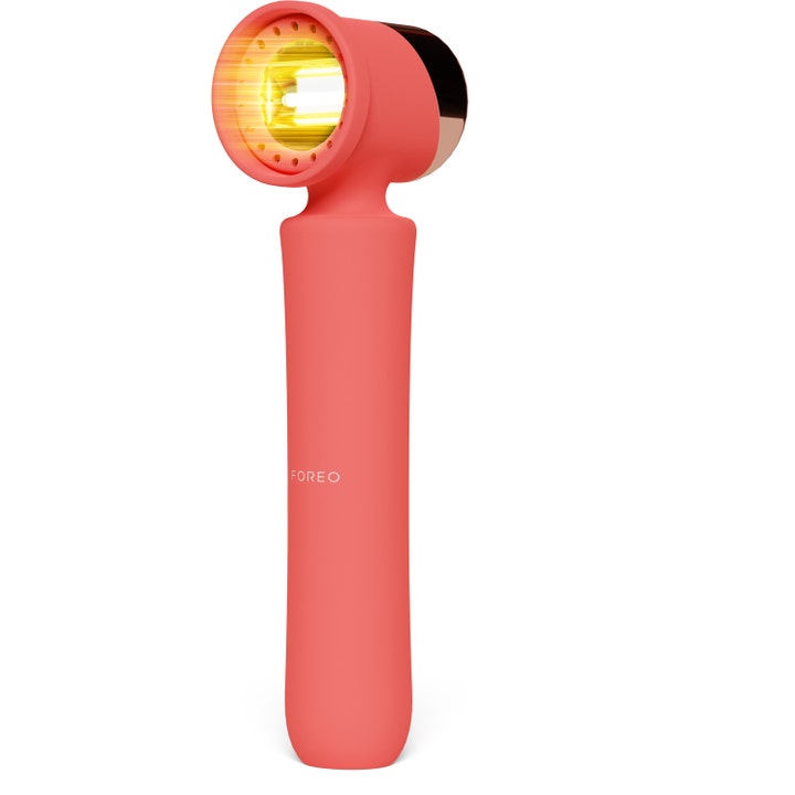 FOREO ESPADA 2 LED-apparat mot kviser i korallrød silikon med et kraftig lysende gult behandlingshode.