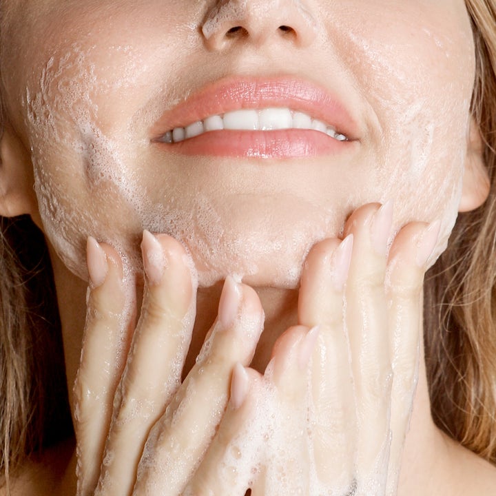 KORA Organics Turmeric Glow Foaming Cleanser 150 ml ansiktsrengjøring i bruk som skaper et rikt hvitt skum på huden
