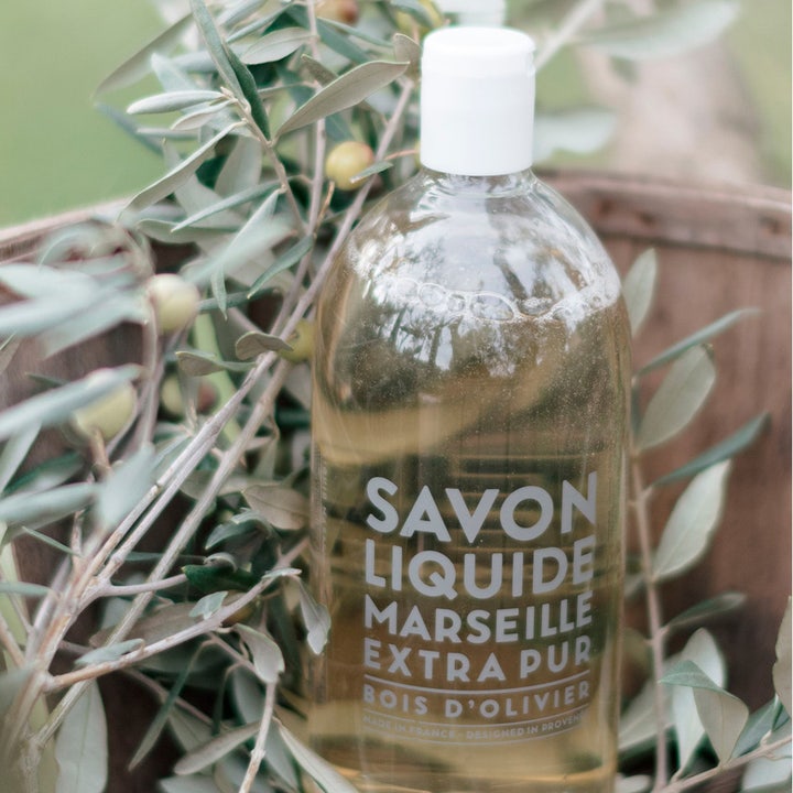 Compagnie de Provence Liquid Marseille Soap Olive Wood 1000 ml pleiende håndsåpe i klar flaske ved grønne olivenkvister