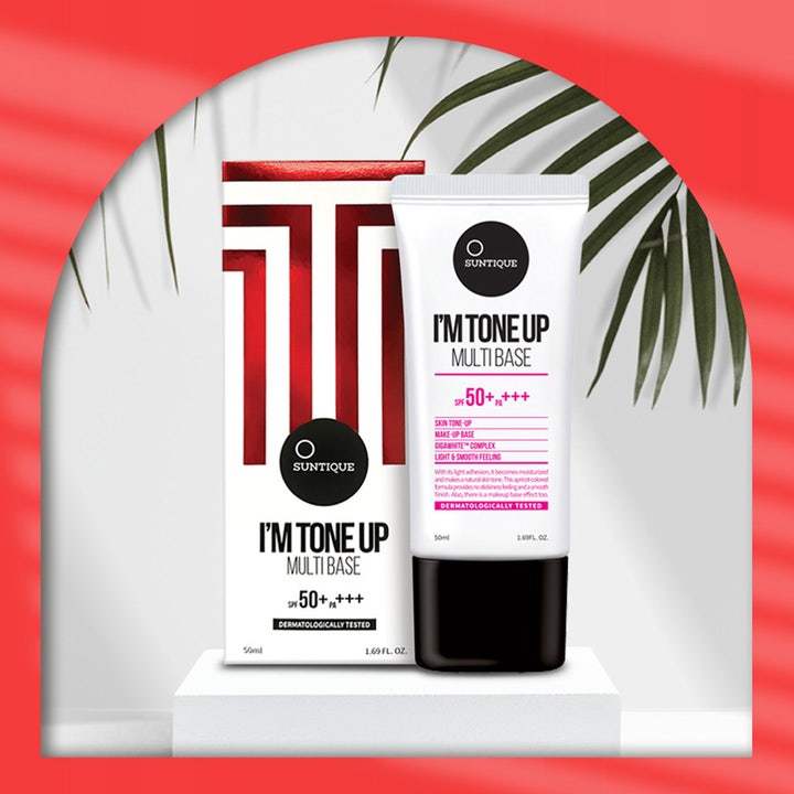 Suntique I'm Tone Up Multi Base 50 ml gir jevnere hudtone i hvit tube og eske med SPF 50+ foran palmegrener