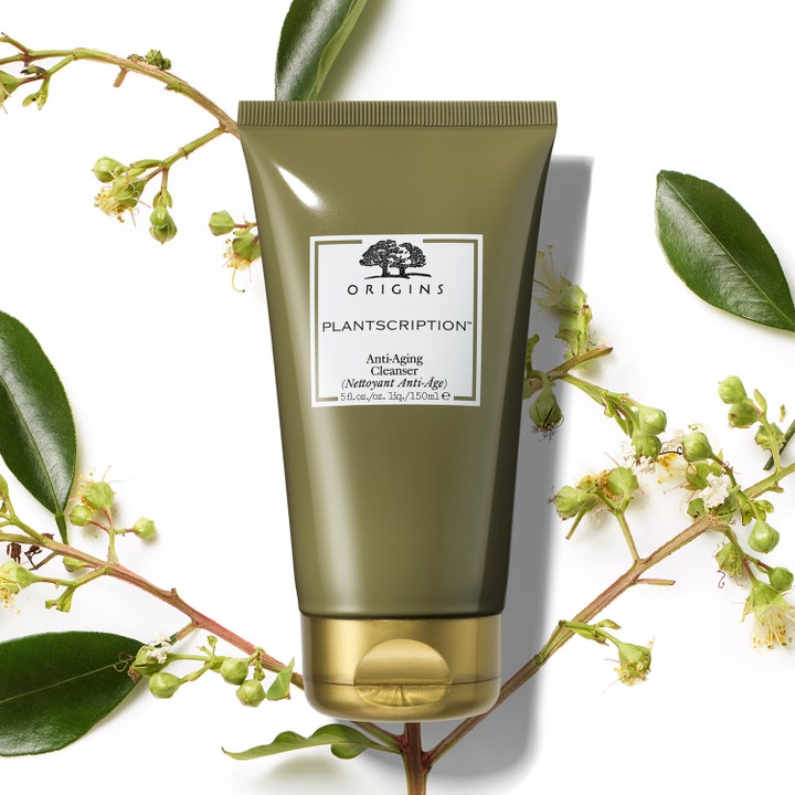 Origins Plantscription Anti-age Cleanser 150 ml ansiktsrengjøring i olivengrønn tube omgitt av blader.