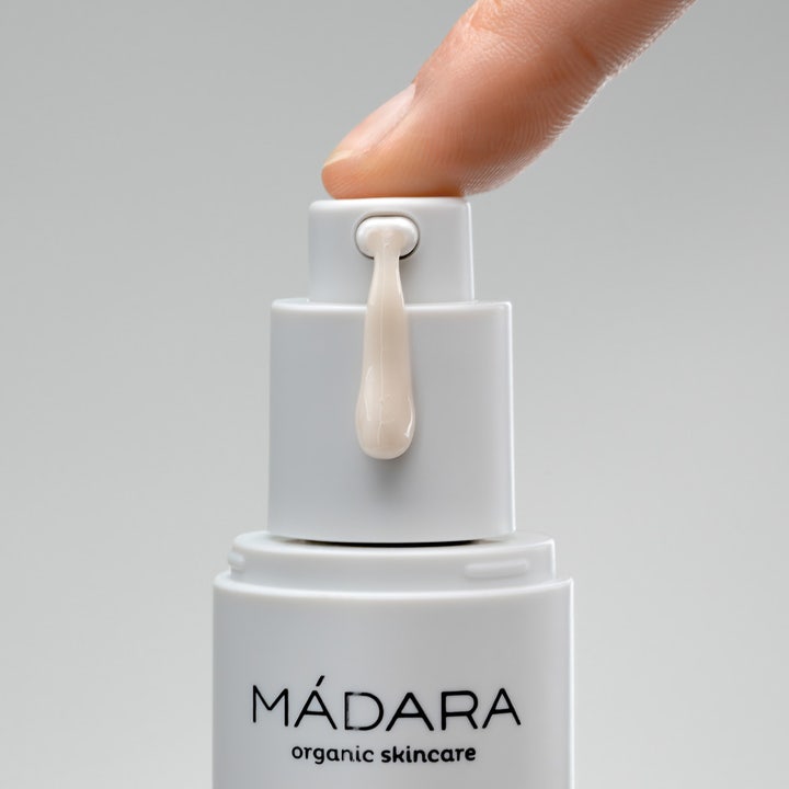 MÁDARA Botanic Niacinamide Alternative 5in1 Serum 30 ml ansiktsserum med en lys dråpe som trykkes ut fra hvit pumpe.