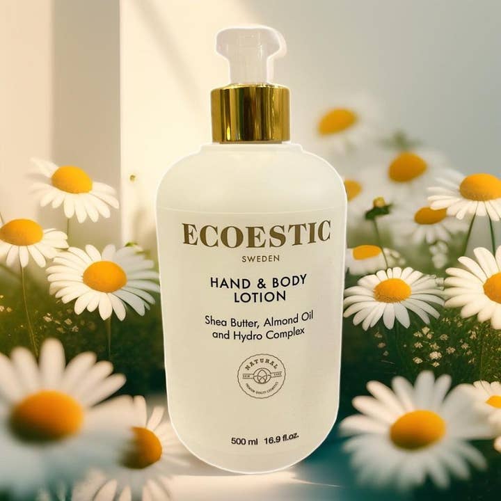 ECOESTIC Hand & Body lotion 500 ml fuktighetskrem med sheasmør i hvit pumpeflaske omgitt av prestekrager