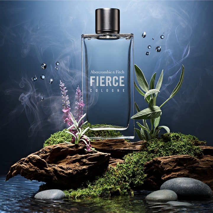 Abercrombie & Fitch Fierce Cologne herreparfyme i glassflaske på mose og mørkt treverk med røyk og lavendel.