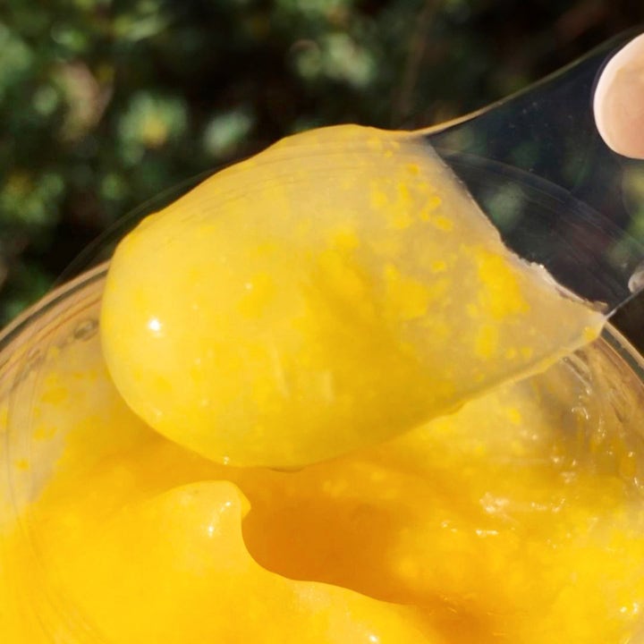 Saturday Skin Yuzu Vitamin C Sleep Mask 50 ml nattmaske med Vitamin C har en gul gelékonsistens med korn på en spatel.