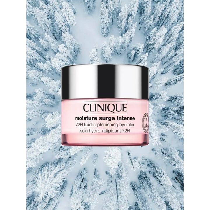 Clinique Moisture Surge Intense 72H 125 ml fuktighetskrem i rosa krukke mot en snødekket vinterskog.