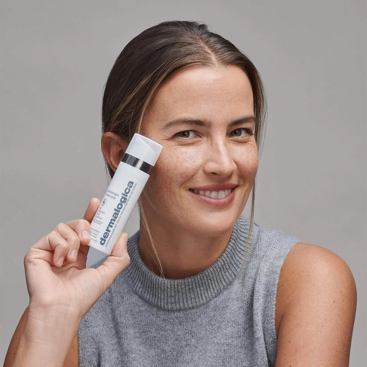 Dermalogica Powerbright Moisturizer SPF50 50 ml ansiktskrem mot pigmentflekker holdt av en smilende kvinne