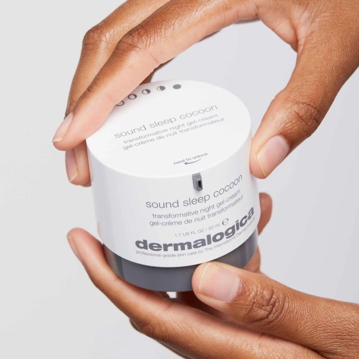 Dermalogica Sound Sleep Cocoon 50 ml nattkrem i hvit og grå krukke som holdes av to hender