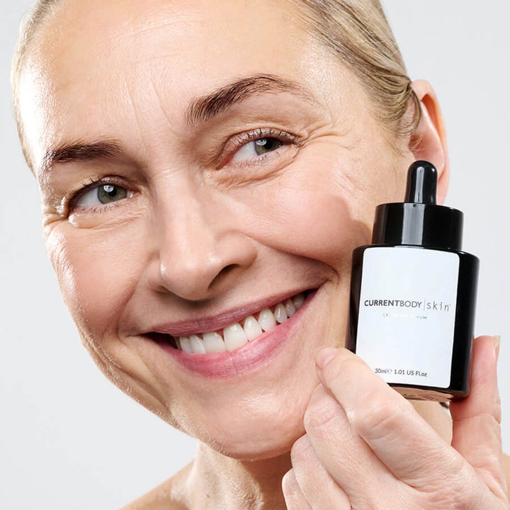 Currentbody Skin Green Tea Serum 30 ml beroligende ansiktsserum holdes av en smilende kvinne