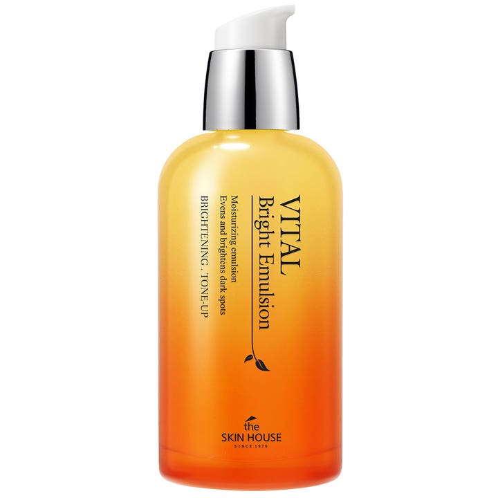 The Skin House Vital Bright Emulsion som jevner ut mørke flekker i en gul og oransje flaske med sølvpumpe.