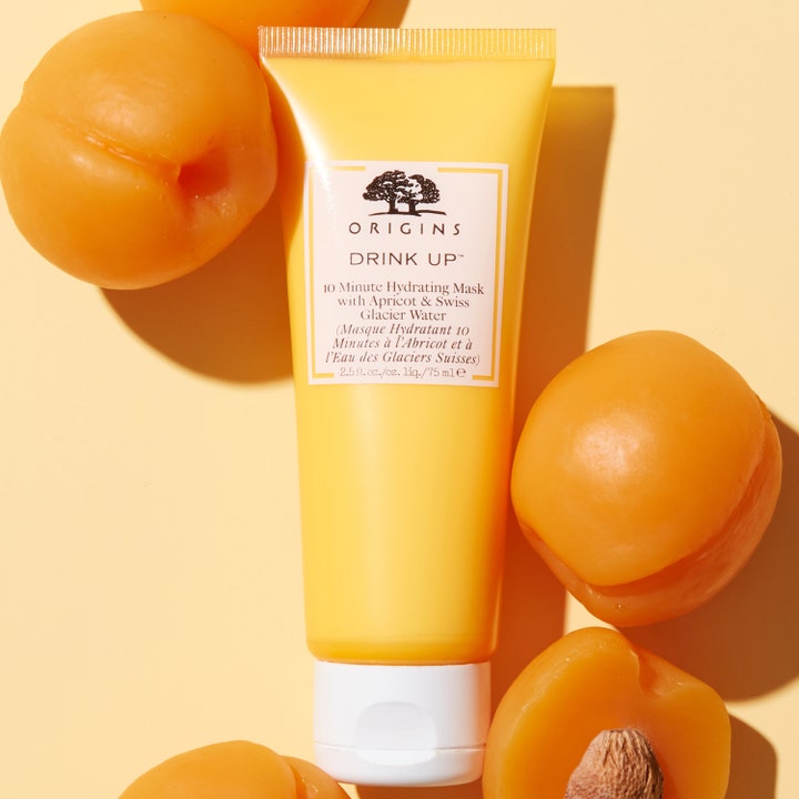 Origins Drink Up 10 Minute Mask 75 ml fuktgivende ansiktsmaske i gul tube omgitt av friske aprikoser
