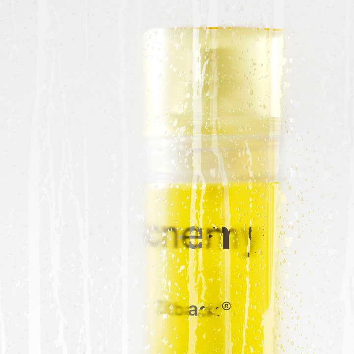 Niche Beauty Lab Acnemy Zitback 80 ml kroppsspray mot kviser i gul flaske bak en våt glassflate