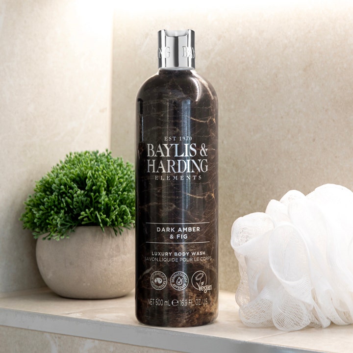 Baylis & Harding Elements Body Wash Dark Amber & Fig 500 ml vegansk dusjsåpe i mørk marmorflaske ved en hvit badesvamp.