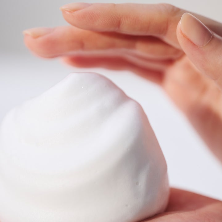 Sensai Silky Purifying Creamy Soap N 125 ml ansiktsrens som skaper et fløyelsmykt hvitt skum i hånden.