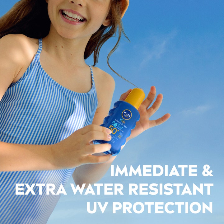 NIVEA Sun Protect & Care Kids Spray 200 ml gir vannresistent solfaktor 50 og holdes av et barn mot en klar blå himmel.