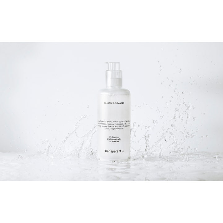 Transparent Lab Oil-Based Cleanser 200 ml ansiktsrens med squalane i hvit pumpeflaske omgitt av vannsprut.