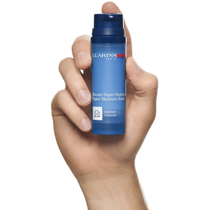 Clarins Men Super Moisture Balm 50 ml fuktighetsgivende ansiktskrem i blå pumpeflaske som holdes i en hånd