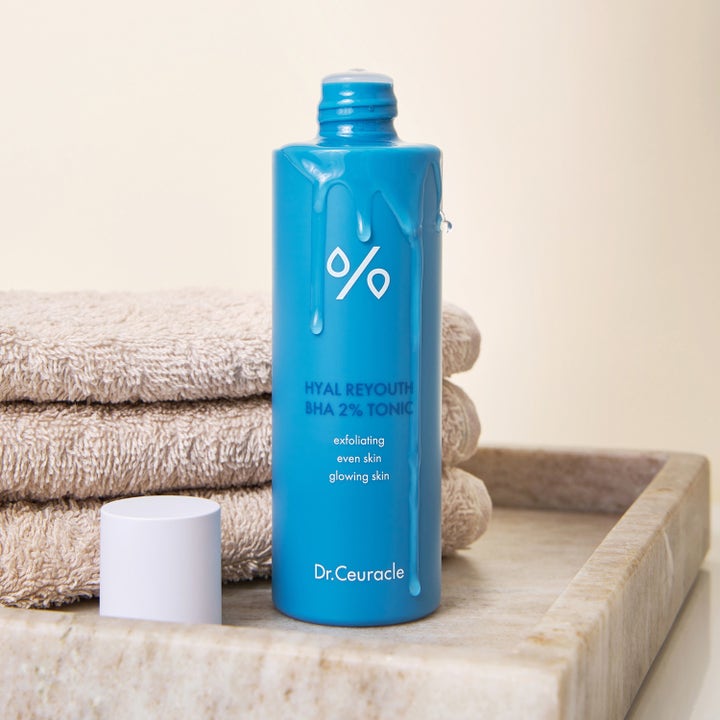 Dr. Ceuracle Hyal Reyouth BHA 2% Tonic 100 ml eksfolierende toner i blå flaske med flytende dråper og håndklær