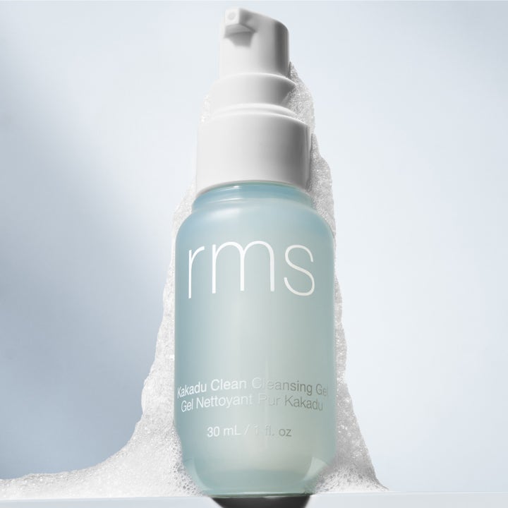 RMS Beauty Kakadu Clean Cleansing Gel 30 ml rengjøringsgel i frostet blå pumpeflaske omgitt av luftig hvitt skum.