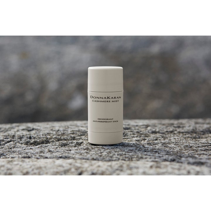 DKNY Cashmere Mist Deostick 50 ml anti-perspirant i beige hylse motvirker fukt og står på en grå steinoverflate