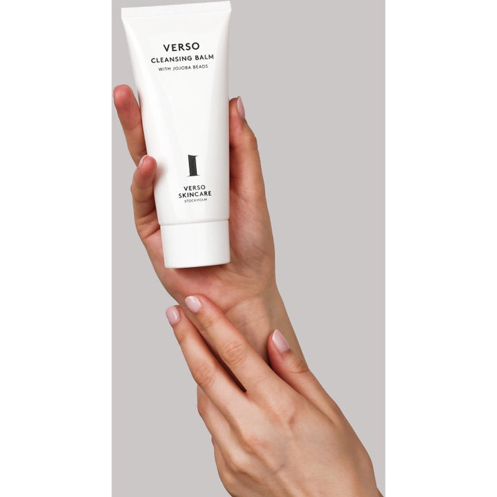 Verso N°1 Cleansing Balm 100 ml ansiktsrengjøring med jojobakorn i hvit tube som holdes av hender
