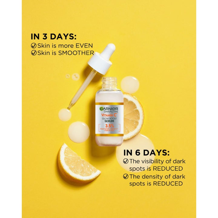 Garnier SkinActive Vitamin C Serum mot mørke flekker i glassflaske med pipette ved siden av friske sitronskiver.