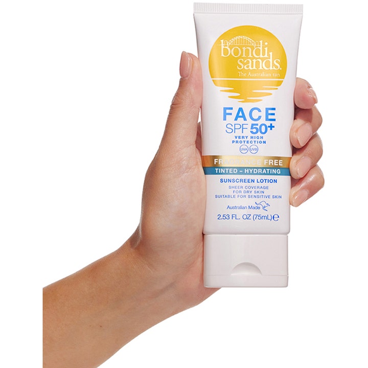 Bondi Sands SPF50+ Hydrating Tinted Face Lotion 75 ml farget solkrem i hvit tube holdes av en hånd