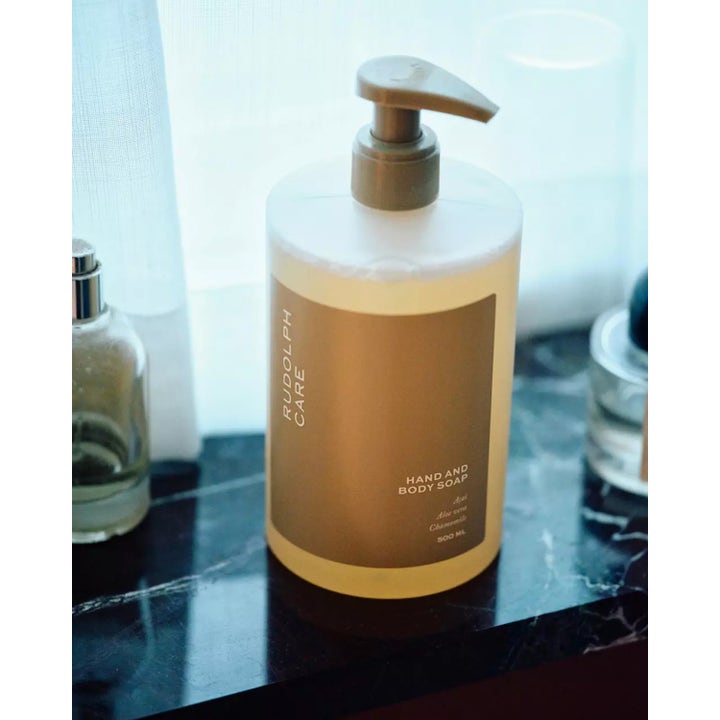 Rudolph Care Hand And Body Soap 500 ml pleiende dusjsåpe i pumpeflaske på mørk marmoroverflate