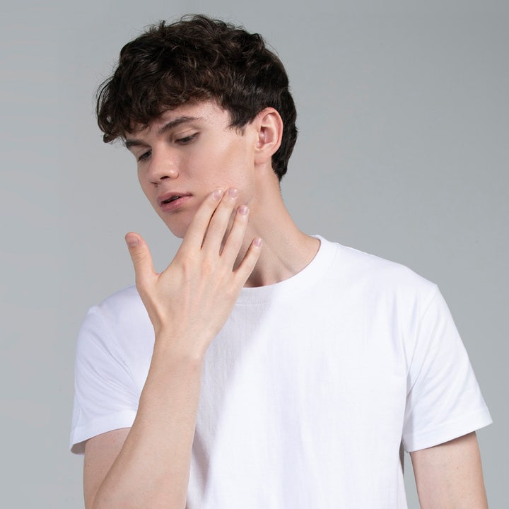 FOREO Blemish Solution 15 ml mot kviser viser en ung mann i hvit t-skjorte som berører kinnet sitt