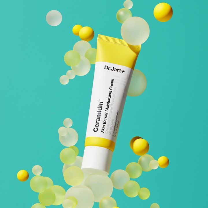 Dr.Jart+ Ceramidin Skin Barrier Moisturizing Cream 50 ml styrker hudbarrieren i gul og hvit tube omgitt av kuler.
