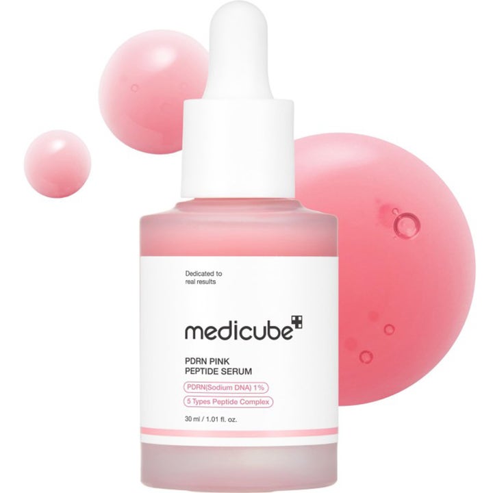 Medicube Pink Peptide Serum 30 ml glødgivende ansiktsserum i rosa glassflaske med hvit pipette og svevende dråper