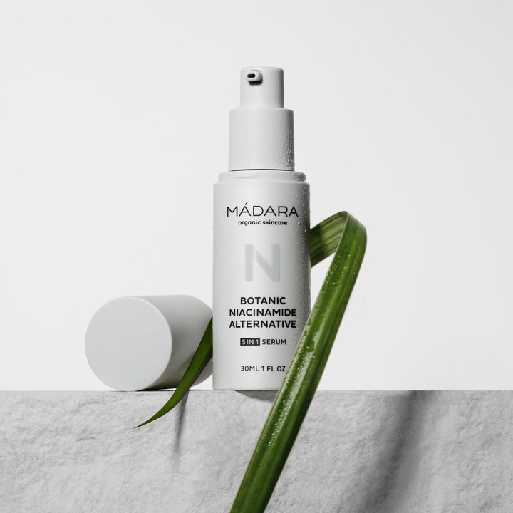 MÁDARA Botanic Niacinamide Alternative 5in1 Serum 30 ml ansiktsserum i hvit pumpeflaske med vanndråper og grønt blad.