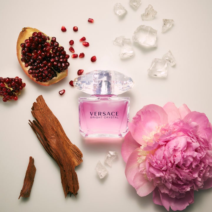 Versace Bright Crystal 50 ml deostick omgitt av friskt granateple, rosa peon og isbiter som gir en floral duft.