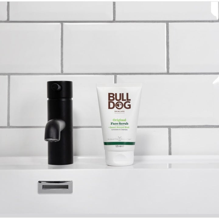 Bulldog Original Face Scrub 125 ml eksfolierende ansiktsskrubb i hvit tube ved en sort baderomskran