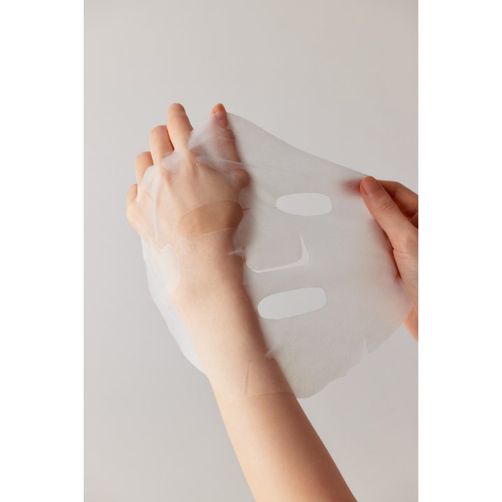Some By Mi Retinol Intense Daily Mask 30 stk ansiktsmaske av tynt hvitt stoff som holdes opp av hender