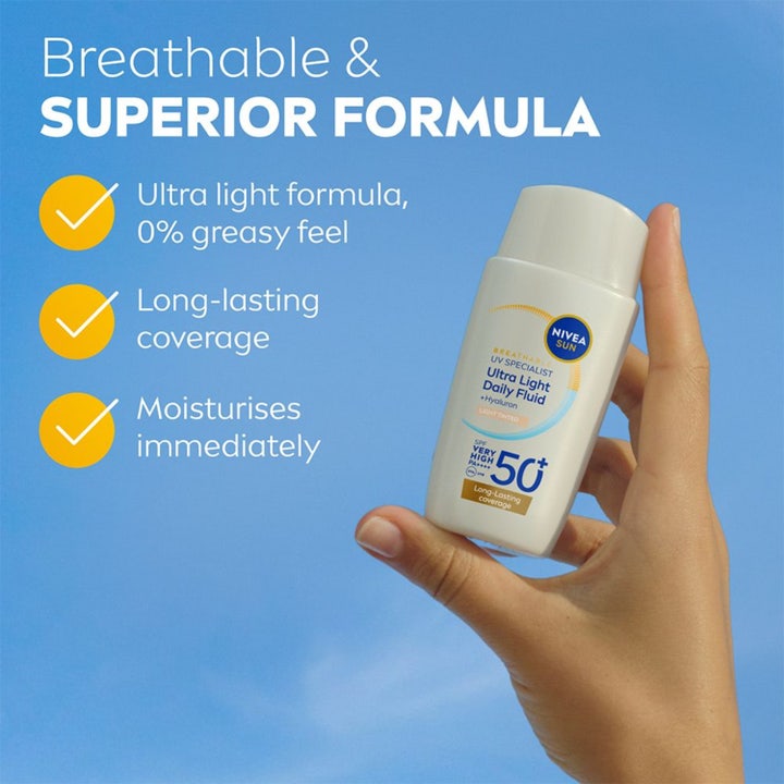 NIVEA UV Face Ultra Fluid Light Tinted SPF50+ 40 ml solkrem for ansiktet holdes mot en blå himmel.