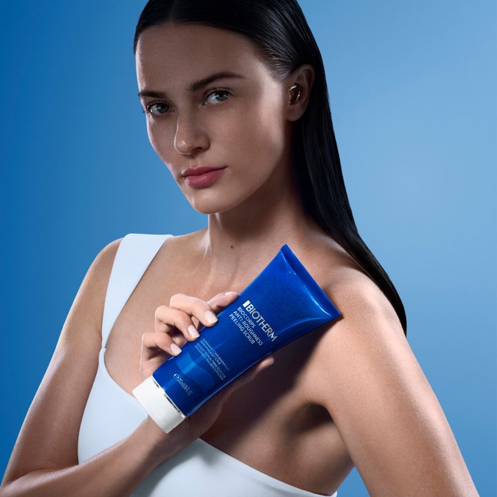 Biotherm Biocorps Body Scrub 200 ml eksfolierende kroppsskrubb som kvinne holder mot skulderen.