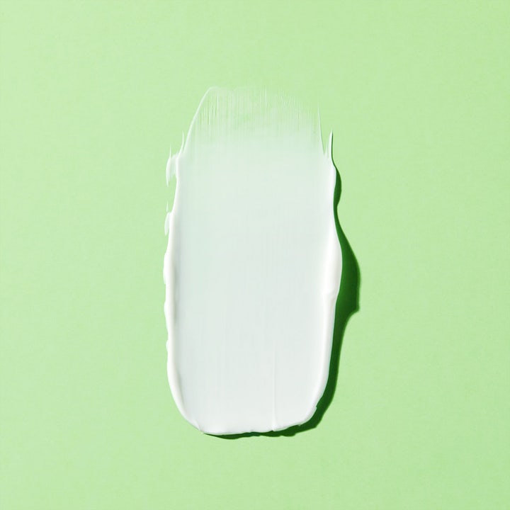 Nuxe Body Reve De Thé Firming Cream 200 ml oppstrammende kroppskrem vist som hvit fyldig tekstur på grønn bakgrunn