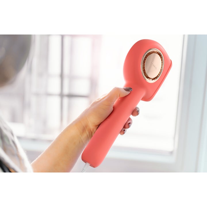 FOREO PEACH 2 Pro Max 1 stk IPL-hårfjerner gir glatt hud ferskenfarget apparat med gulldetaljer i en hånd.